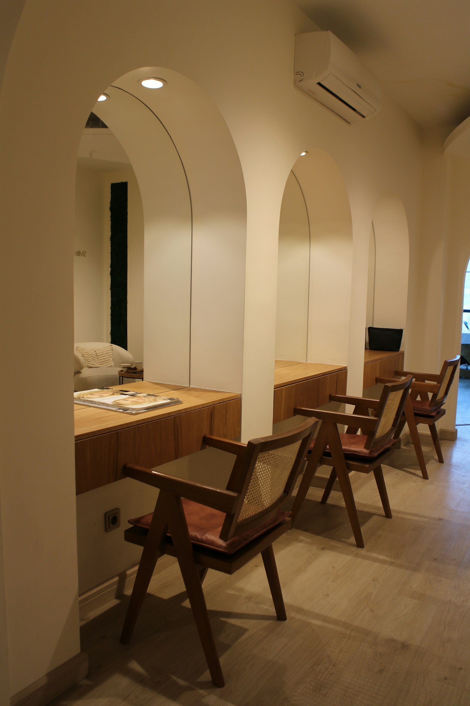 Sala de espera luminosa con arcos y sillas de madera
