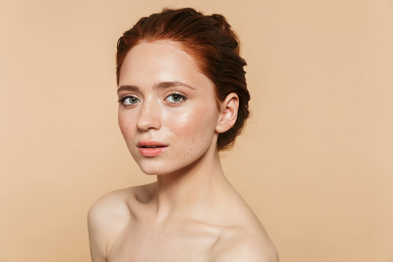 Mujer con piel natural y luminosa sobre fondo beige